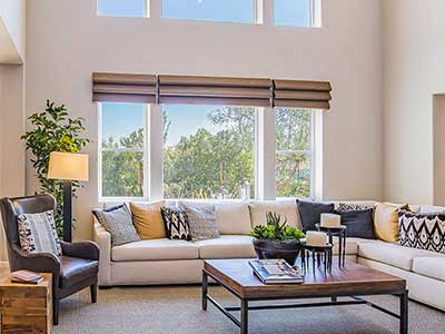 Modern, open living room space with Anlin windows on the wall behind the sofa