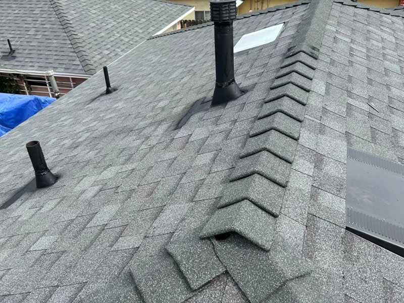 Close up of a residential roof with new gray shingles installed by Modern Instinct Construction